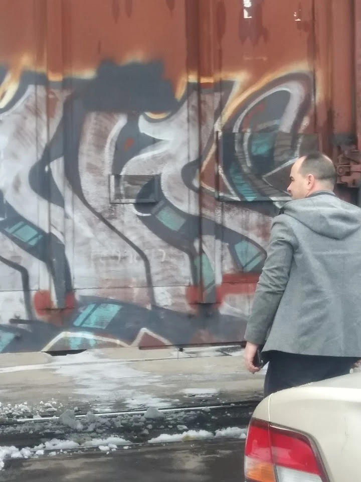 Person walking near graffiti-covered wall.