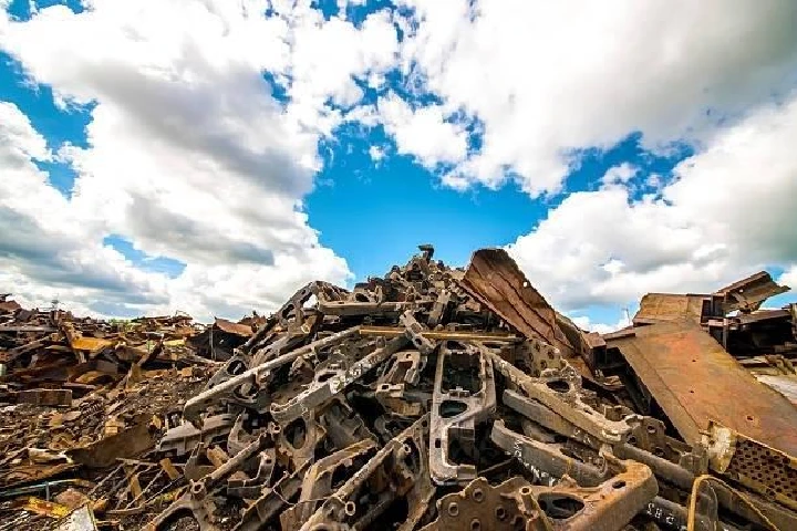 Pile of metal scraps under a blue sky.