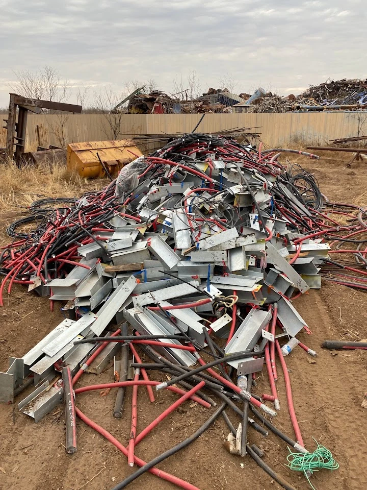 Piled metal scraps and cables at a recycling facility.