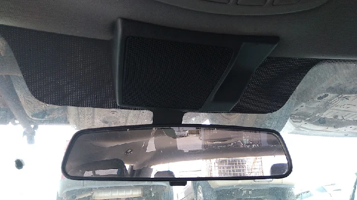 Rearview mirror and overhead speaker in a vehicle.