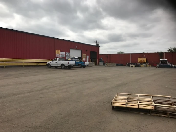 Recycling facility exterior with parked vehicles.