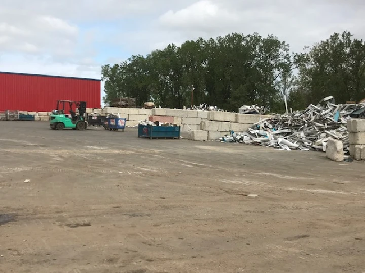 Recycling yard with containers and materials stacked.