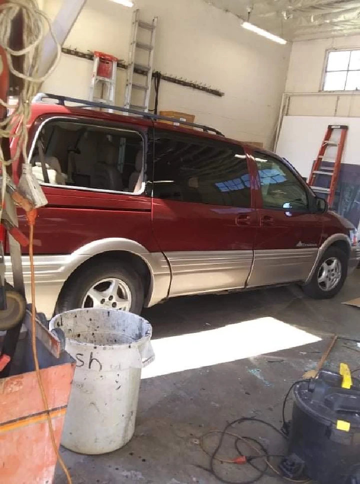 Red minivan parked in an auto parts shop.