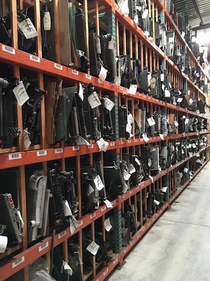 Rows of auto parts on shelves in a recycling facility.