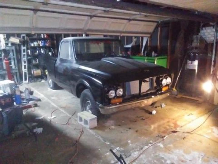 Rustic garage with a black pickup truck.