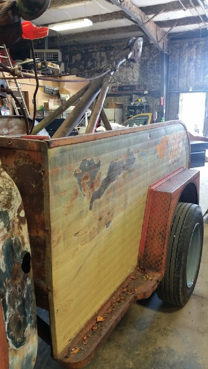 Rusty auto parts trailer inside shop.