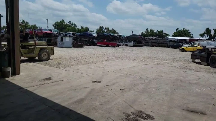 Salvage yard with stacked vehicles and parts.