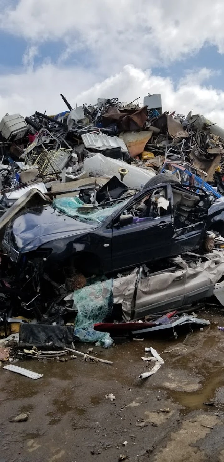 Scrap cars piled at a recycling facility.