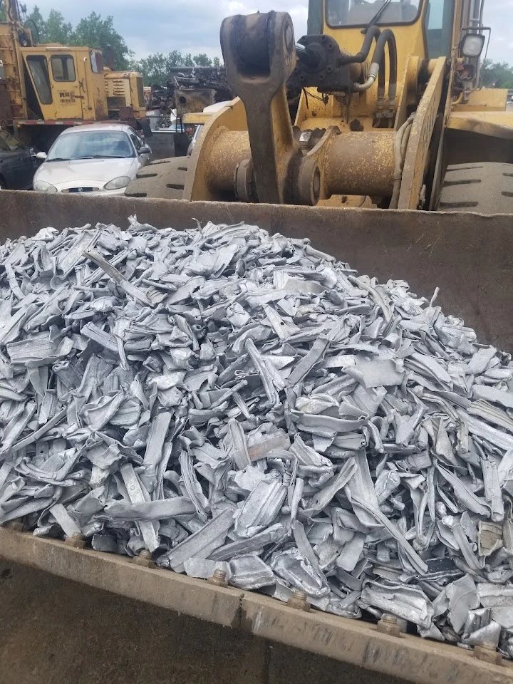 Scrap metal pile in a loader's bucket.