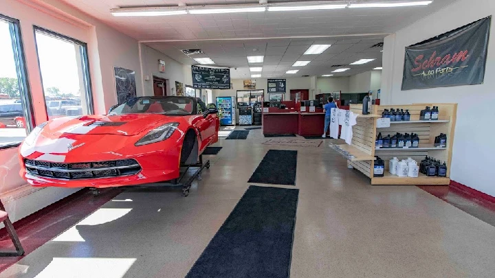 Showroom interior with a red car and auto supplies.