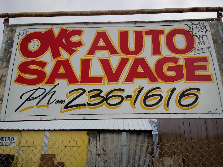 Sign for OKC Auto Salvage with contact number.