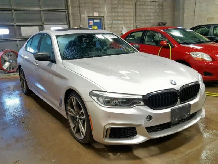 Silver BMW sedan in a garage setting.