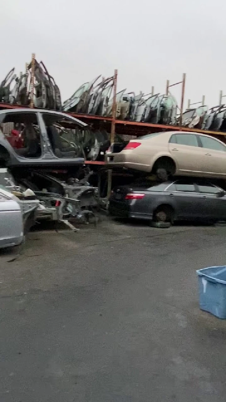 Stacked cars in an auto recycling yard.