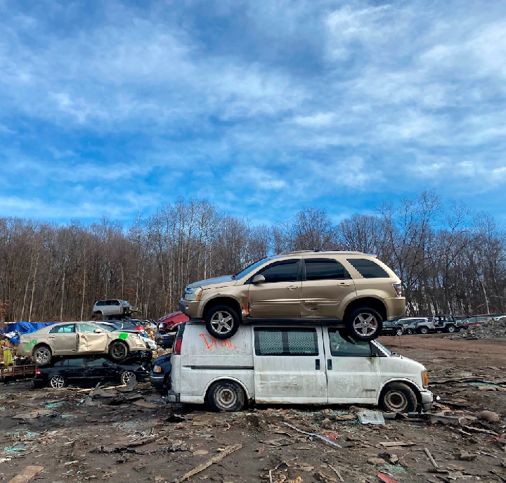 Stacked vehicles in an auto salvage yard.