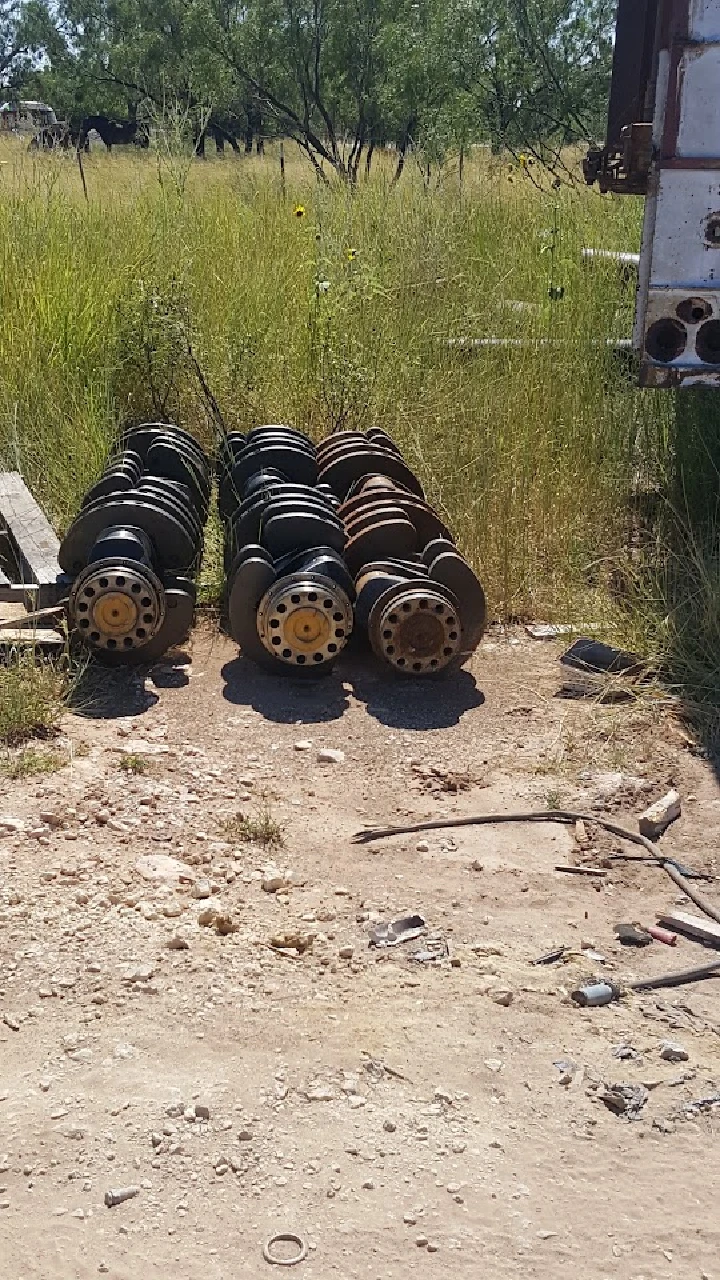 Stacks of recycled metal parts on a dirt path.