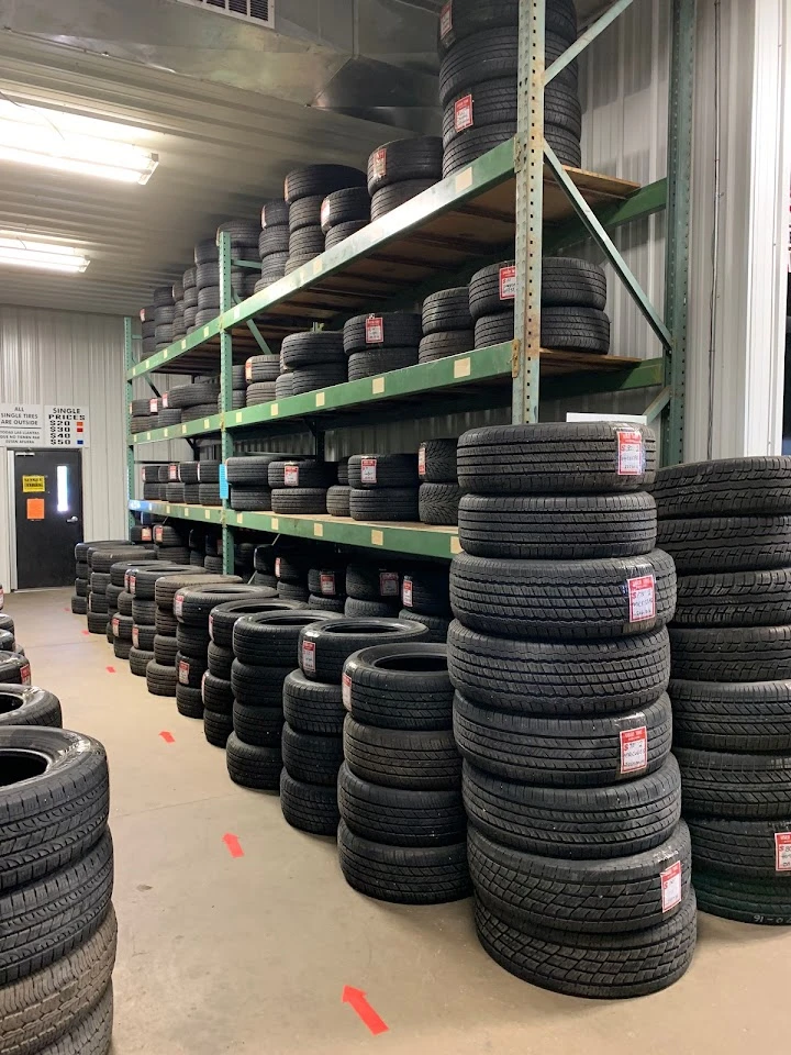 Tires stacked on shelves in an auto parts store.