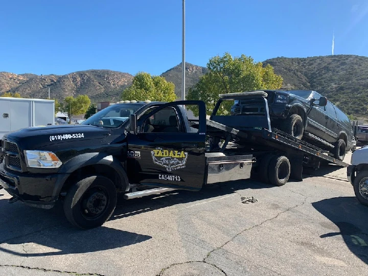 Tow truck carrying a vehicle in San Diego area.