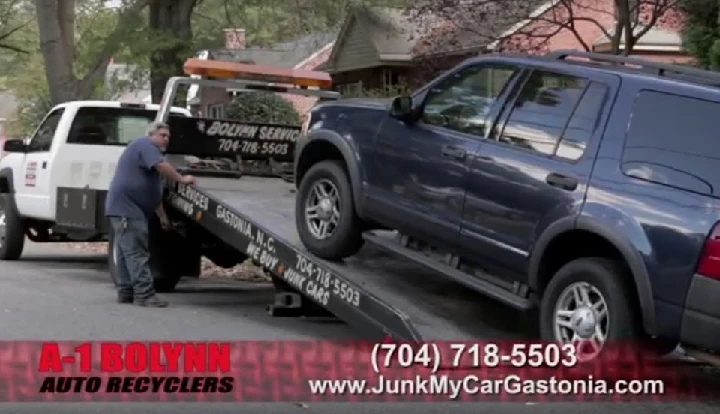 Tow truck loading a vehicle for recycling service.