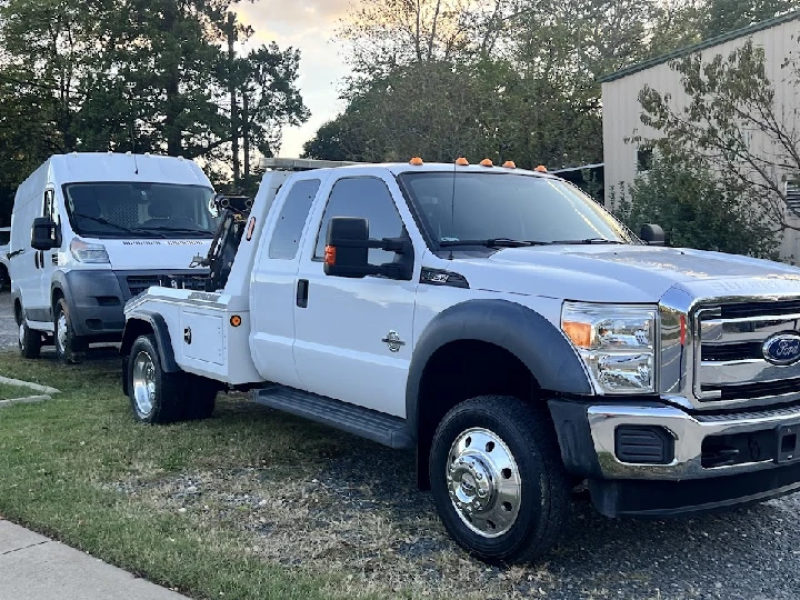 Tow truck parked beside a van in Charlotte.