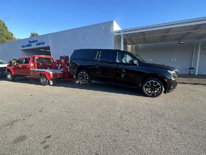 Tow truck picking up a vehicle outside a shop.