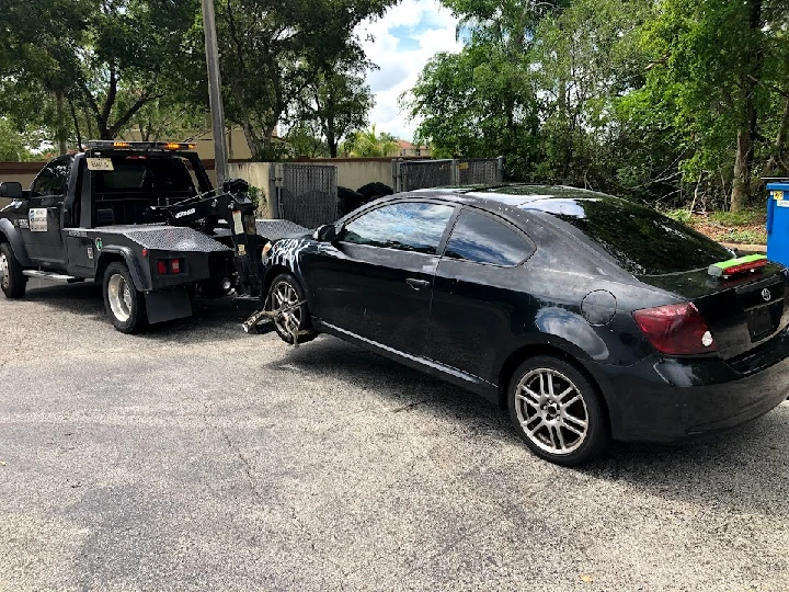 Tow truck retrieving a junk car in Fort Lauderdale.