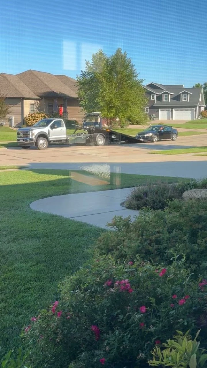 Tow truck servicing a vehicle on a residential street.