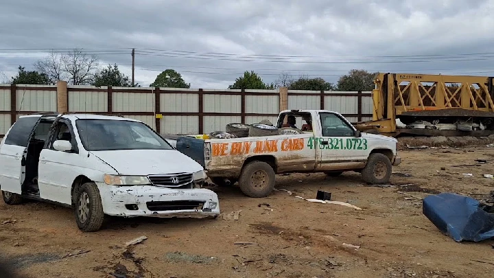 Two junk cars in a scrapyard for recycling.