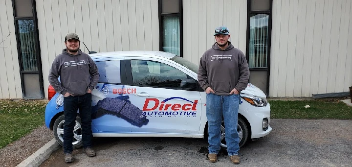 Two men stand by a Direct Automotive vehicle.