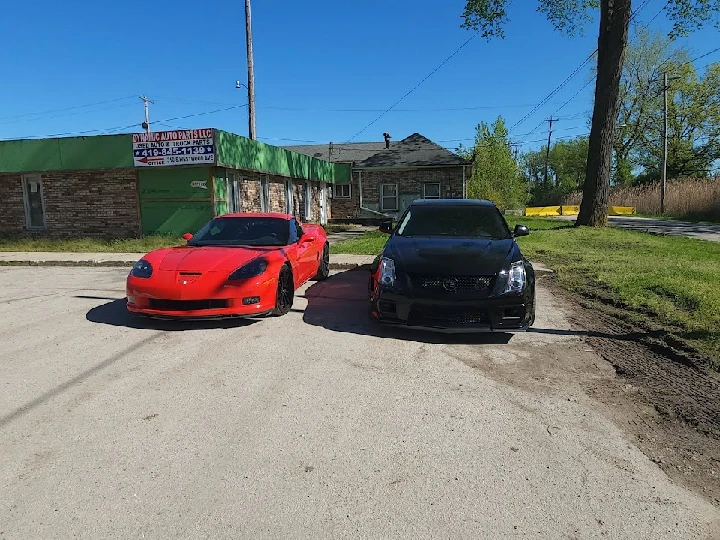 Two sporty cars parked in front of a store.