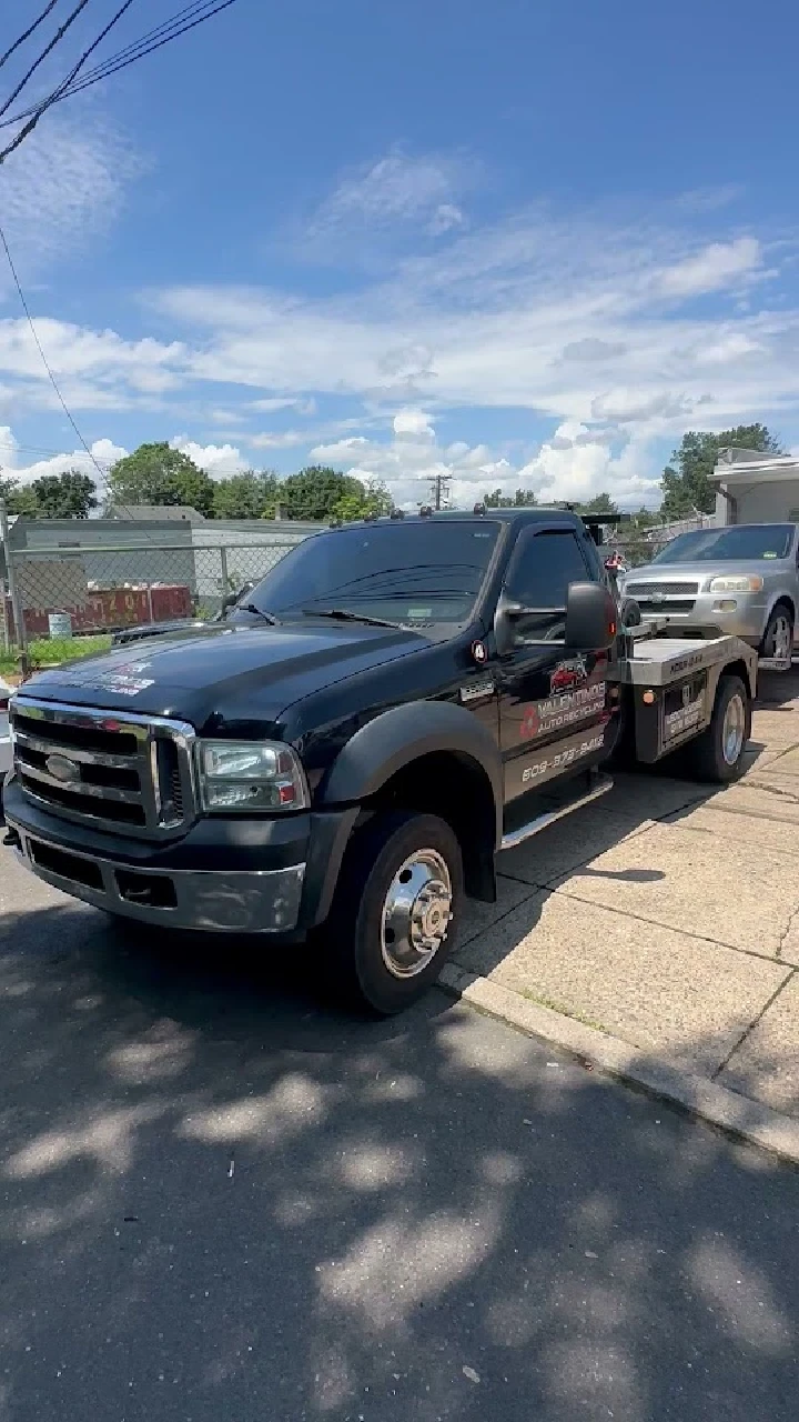 Valentino's Auto Recycling tow truck parked outside.