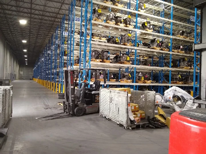 Warehouse interior with parts and a forklift.