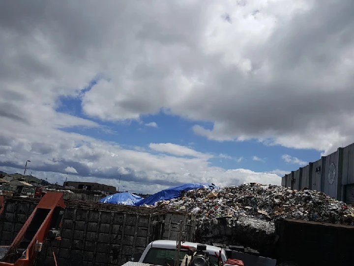 Waste materials piled high under a cloudy sky.