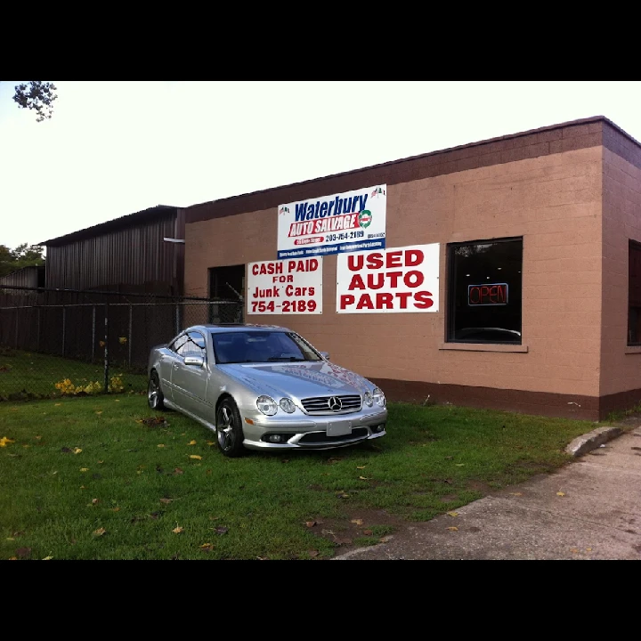 Waterbury Auto Salvage building with a silver car.