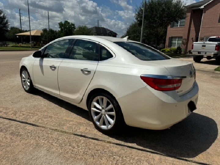 White sedan parked on a sunny street.