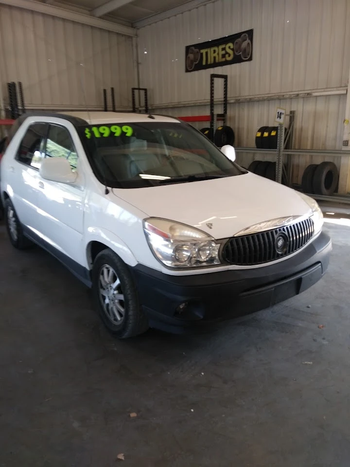 White SUV marked at $1999 for sale indoors.