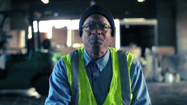 Worker in a warehouse, wearing a safety vest.