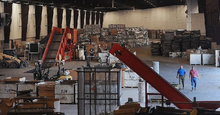 Workers walking through an industrial yard.