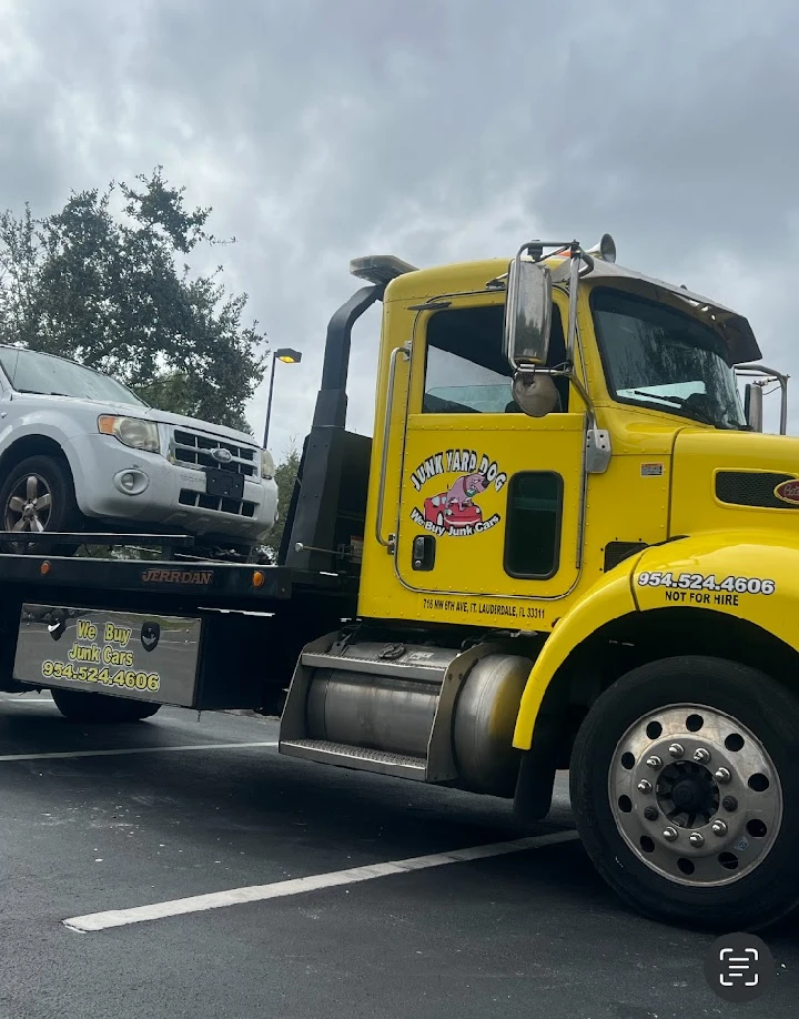 Yellow tow truck loading a car for Junkyard Dog.