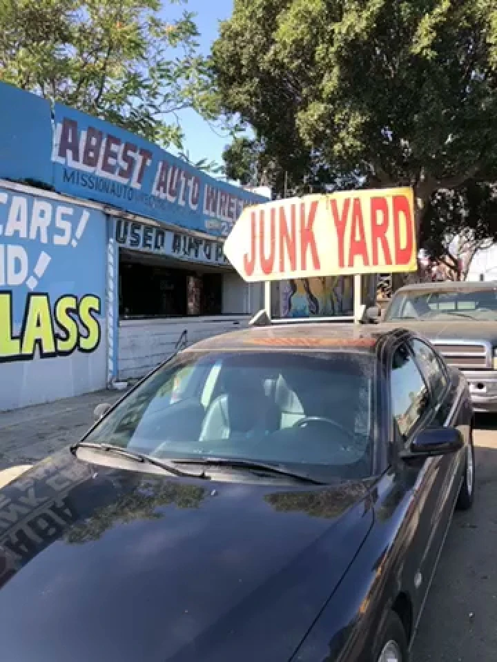 A-Best Auto Wrecking junkyard sign and parked cars.