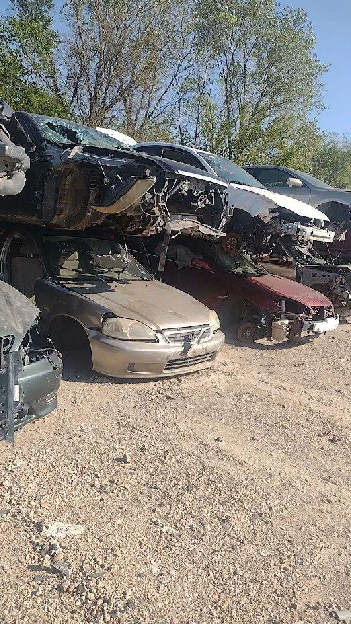 Abandoned cars stacked in a salvage yard.