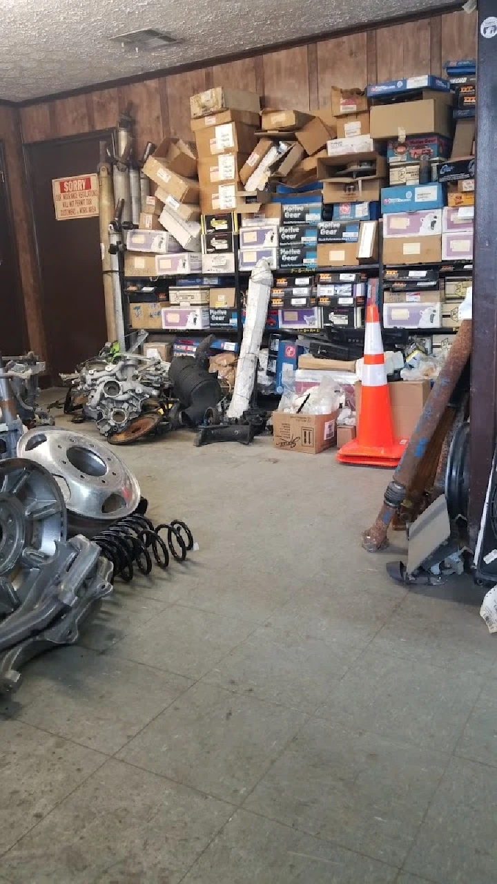 Auto parts and boxes stacked in a salvage workspace.