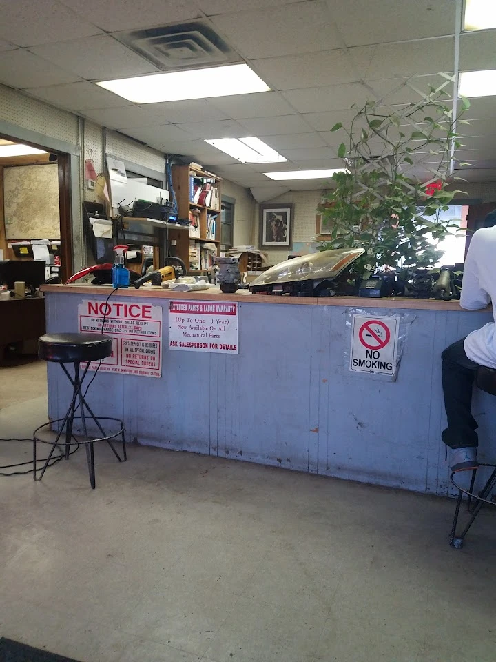 Auto parts counter with signs and customer seating.