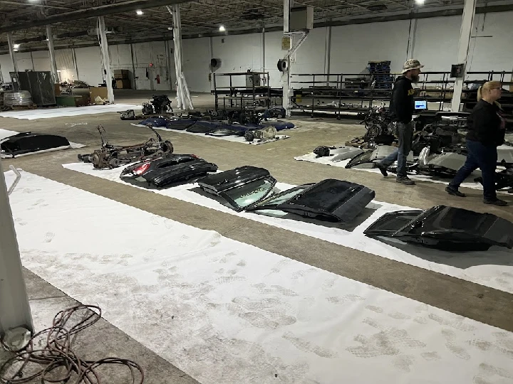 Auto parts laid out in a warehouse for inspection.