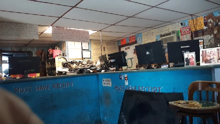 Auto parts shop interior with computers and signage.