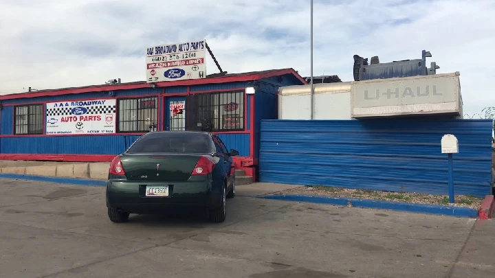 Auto parts store with a green car parked outside.