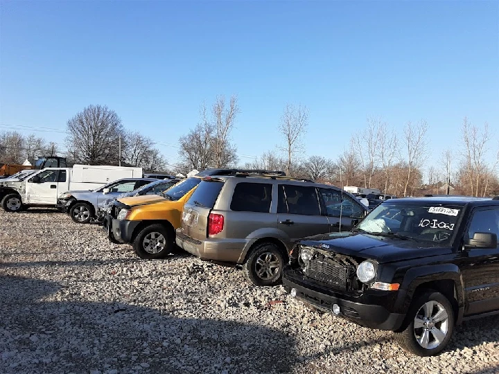 Auto parts yard with several vehicles parked.