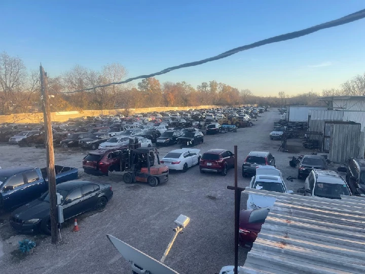 Auto recycling yard with numerous vehicles.