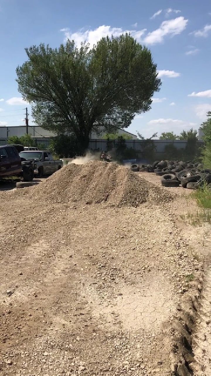 Auto recycling yard with tires and gravel pile.