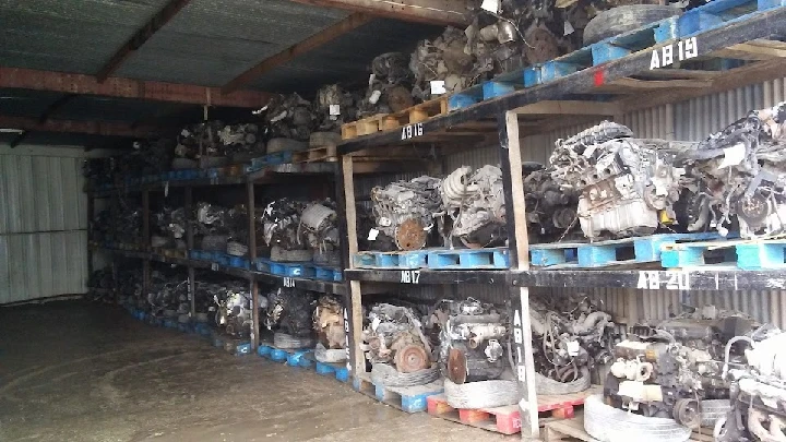 Auto salvage yard with stacked engines in storage.