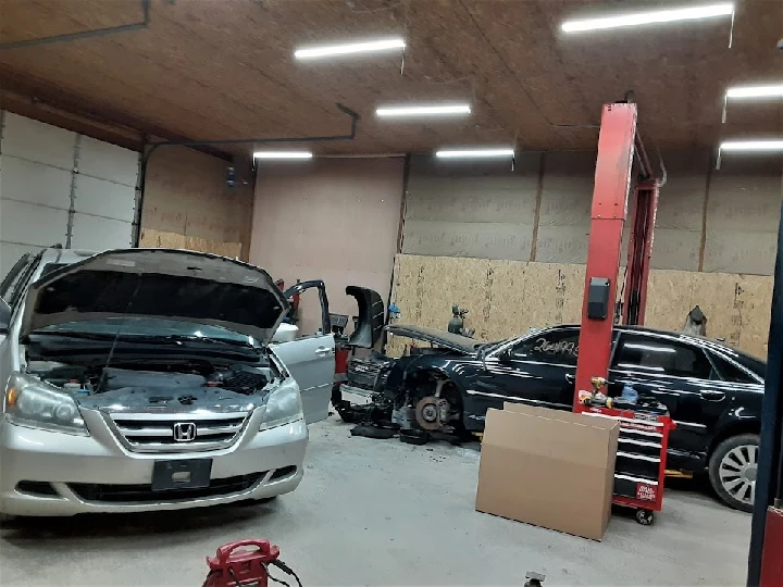 Auto shop interior with cars undergoing repairs.